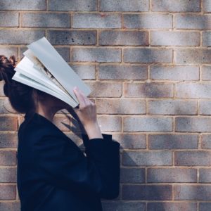 Girl with book over face